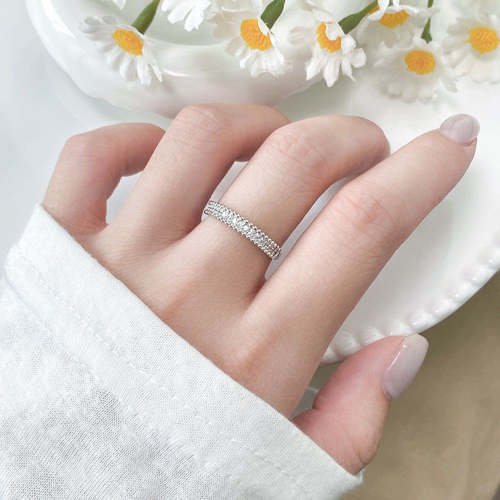 Ein minimalistischer 925er Sterlingsilberring mit Perlen-CZ-Akzenten aus einem Großhandelsset von fünf, gezeigt getragen an einem Finger, um sein elegantes Design für den Alltag zu präsentieren.