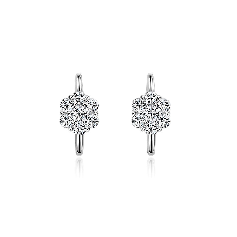 Un primer plano de los pendientes Huggie Floral Clear CZ, exhibiendo el intrincado diseño de flor de circonio cúbico en el aro chapado en rodio.