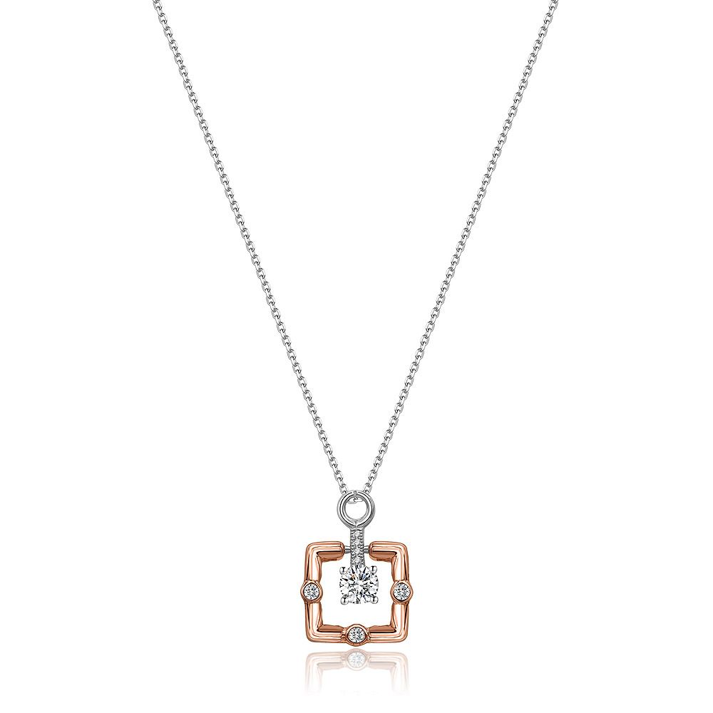 Gros plan du collier pendentif carré bicolore, présentant un cristal Swarovski central serti en argent sterling 925 avec un plaquage en rhodium et en or rose, sur un fond blanc.