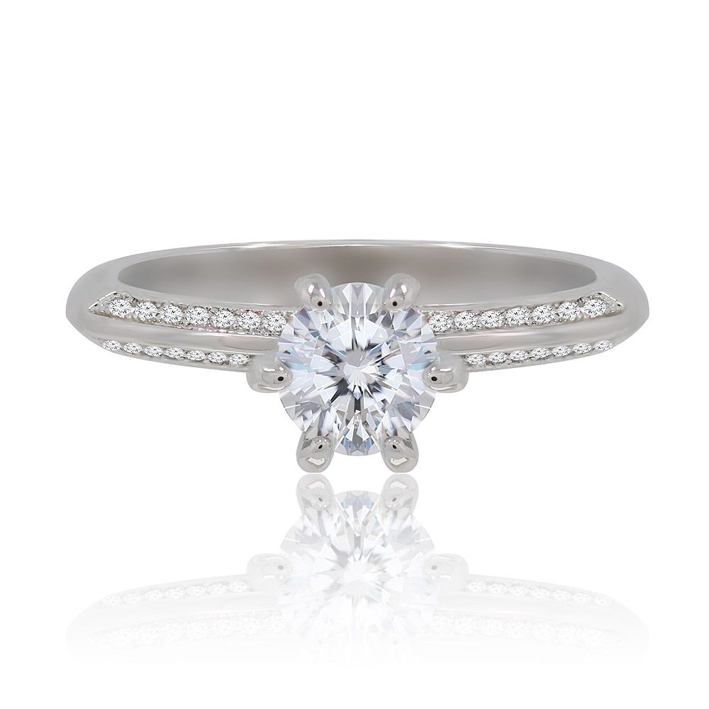 Primo piano dell'Anello Eternità Amore Romantico, che mette in mostra una pietra centrale rotonda in zirconia cubica con pietre più piccole incastonate lungo la fascia in ottone placcato rodio.