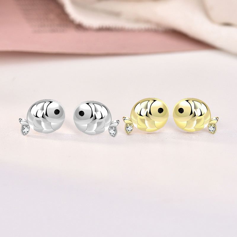 Un paio di orecchini a perno a forma di pesce carpa in argento sterling 925 e un paio di orecchini a perno placcati oro, ciascuno adornato con una scintillante pietra in zirconia cubica.