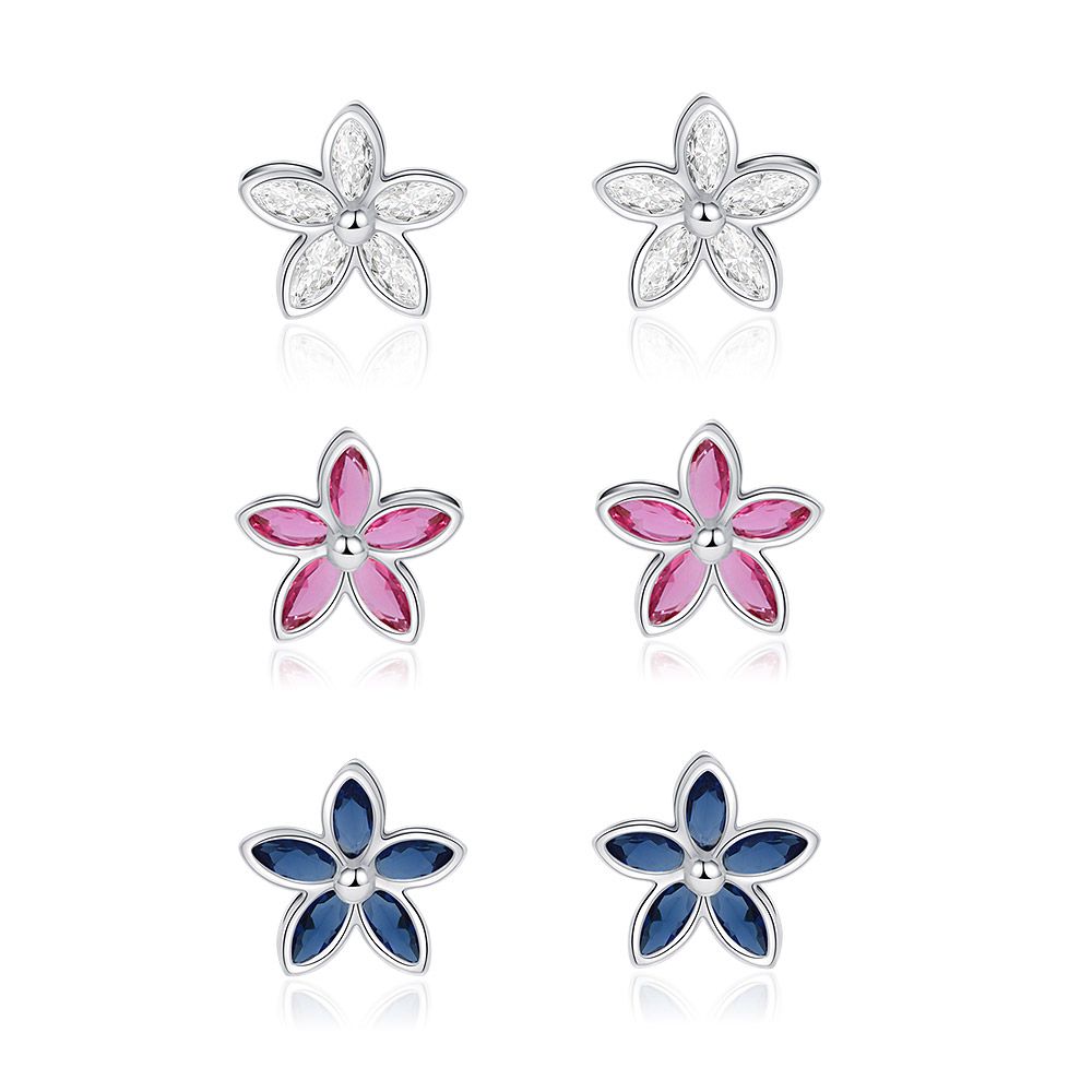 Un ensemble de trois paires de boucles d'oreilles en forme de fleur avec un plaquage en rhodium, présentant des pierres en zircon cubique claires, rose clair et bleu Montana.
