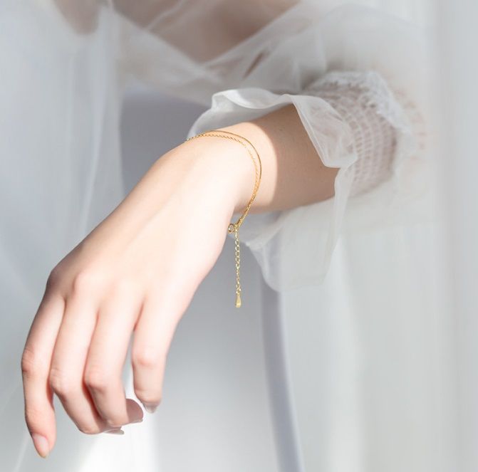 A model wearing the 925 Sterling Silver Gold Plated Double Chain Bracelet, showcasing its elegant design on the wrist.