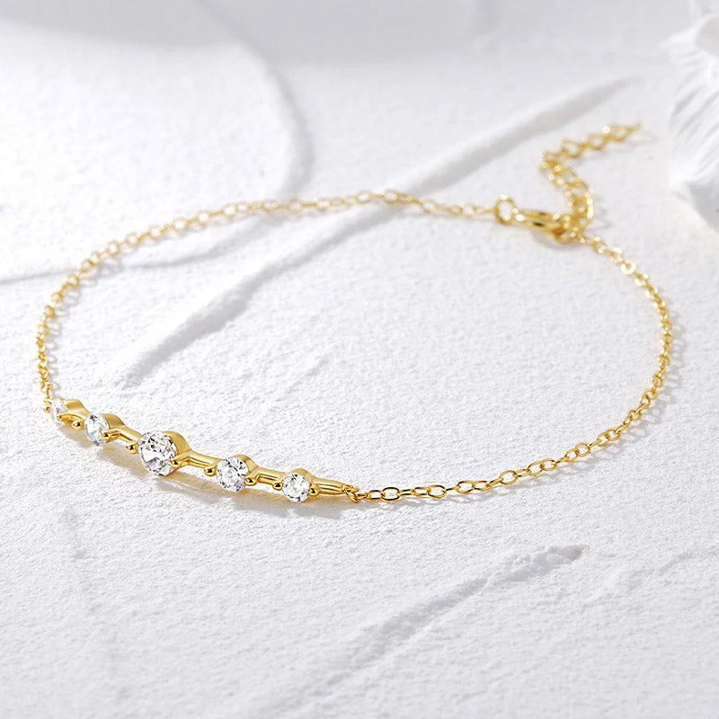Une photo produit d'un bracelet en argent sterling 925 plaqué or avec une seule rangée de cinq pierres en zircon scintillantes, sur fond blanc.