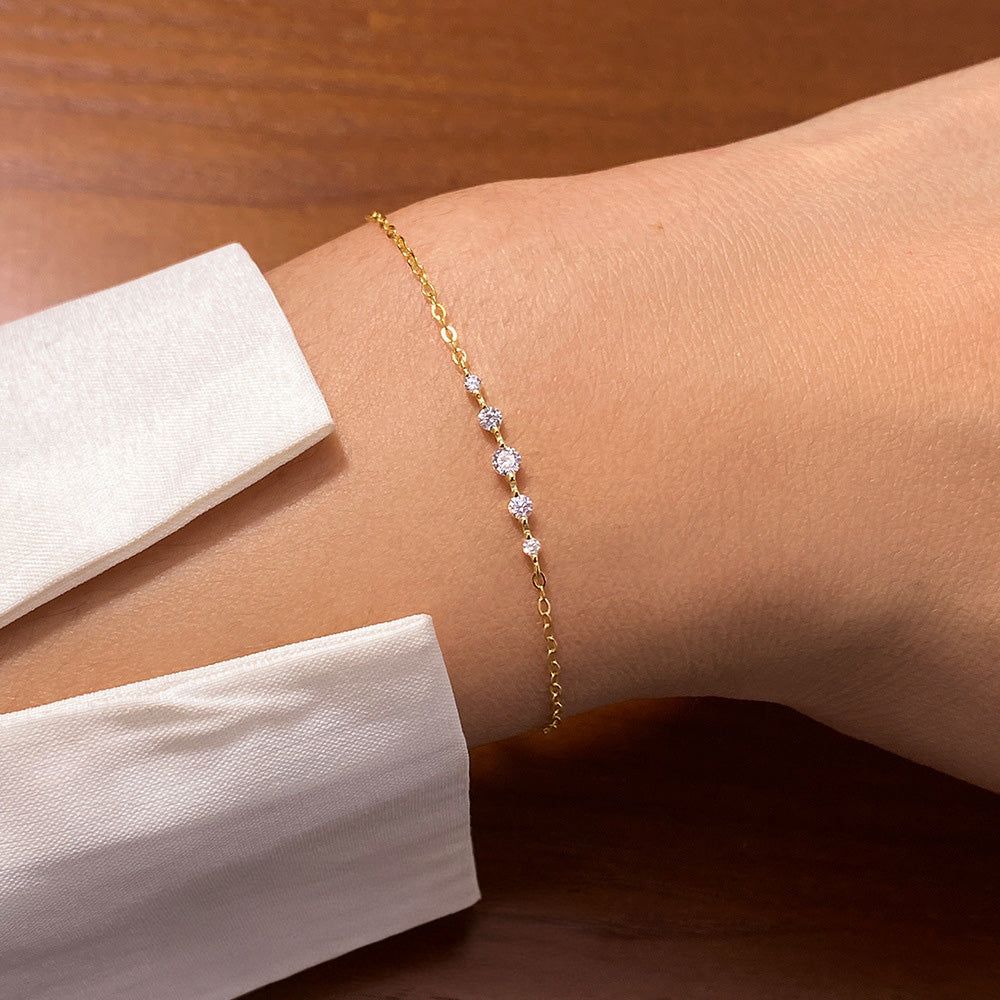 A model wearing the Exquisite Pavé Silver Bracelet, showcasing its gold-tone finish and shimmering pavé gemstones on the wrist.