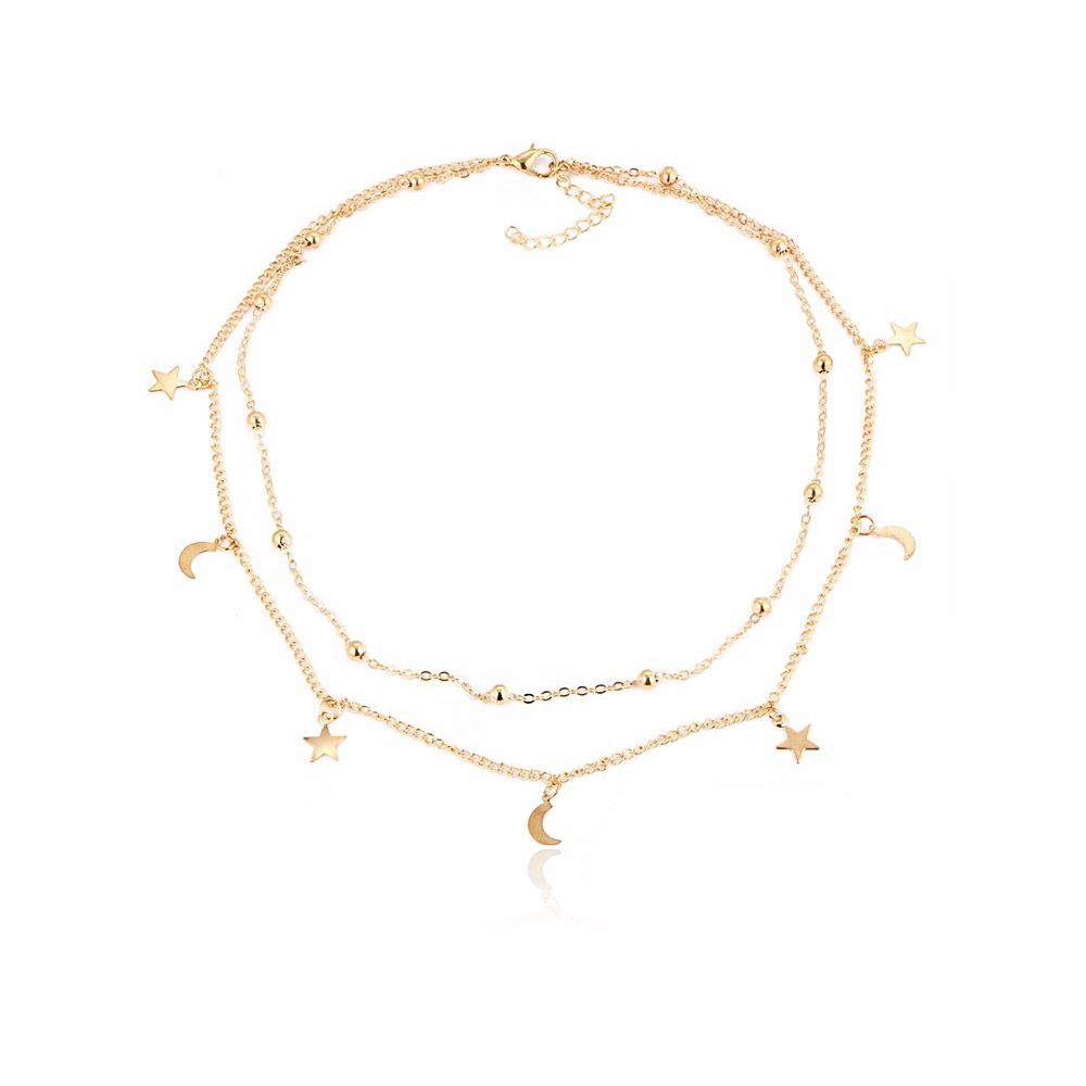 Een delicate dubbelgelaagde vergulde ketting met minimalistische ster- en maanbedels op een witte achtergrond.