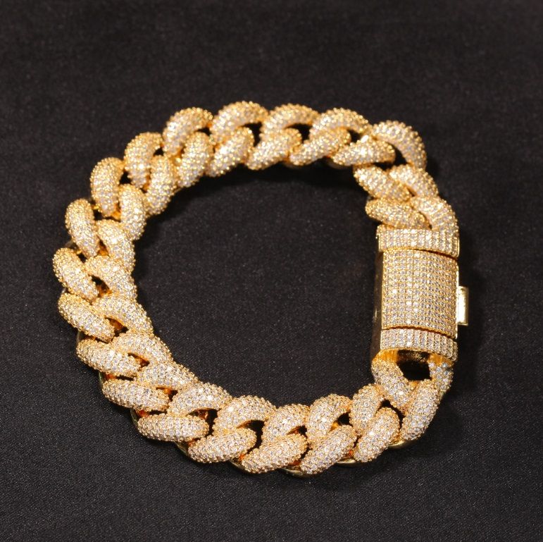 A stunning gold-colored, diamond-encrusted Cuban chain iced out bracelet with a secure clasp, showcasing intricate craftsmanship.