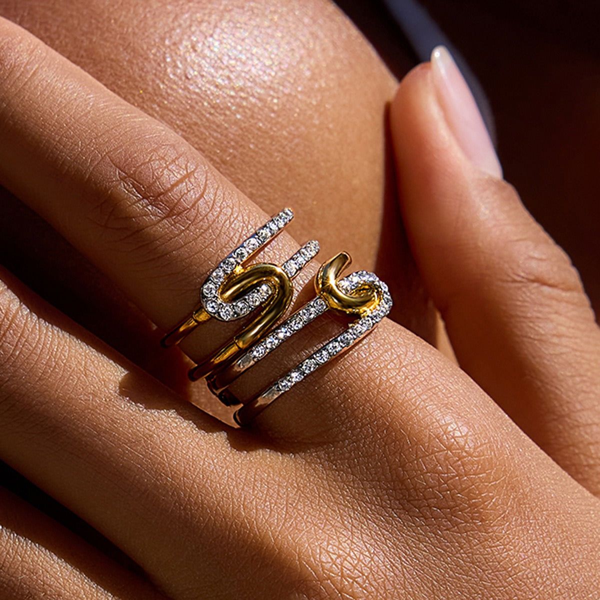 Een close-up van de twee-kleurige gouden en zilveren rhinestone ring set, die de sprankelende stenen en het gemengde metalen ontwerp benadrukt.