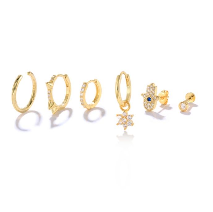 Una colección elegante de seis aretes huggie chapados en oro, con diversos diseños con piedras de circonita cúbica, perfectos para venta al por mayor.