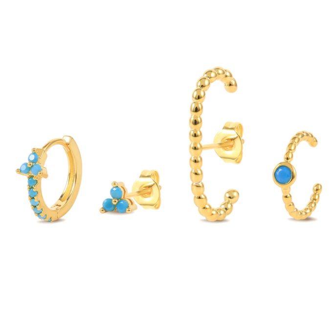 Un ensemble de quatre boucles d'oreilles huggie plaquées or avec des pierres précieuses turquoise vibrantes, présentées sur un fond blanc propre.