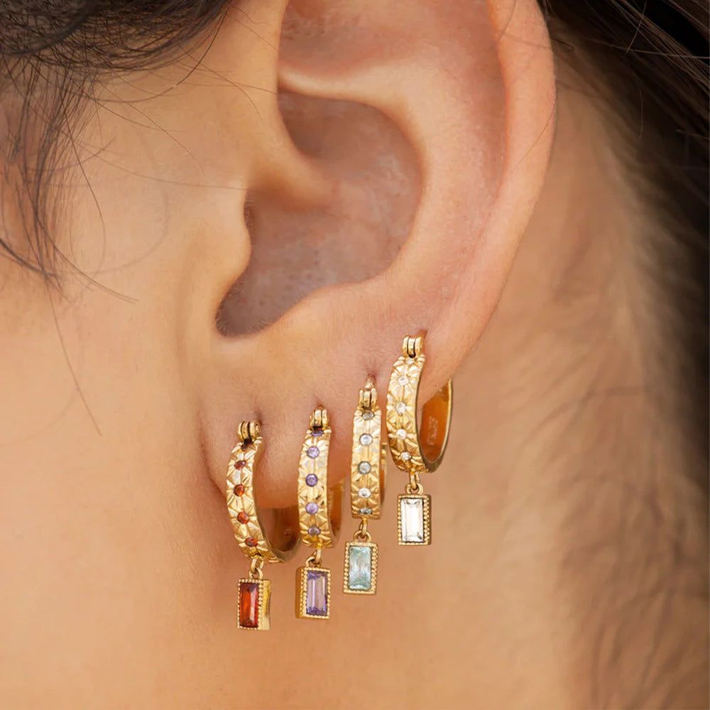 Una vivace collezione di orecchini a cerchio quadrati in zirconia colorata in argento sterling 925 in vari colori di gemme, esposti su uno sfondo bianco.