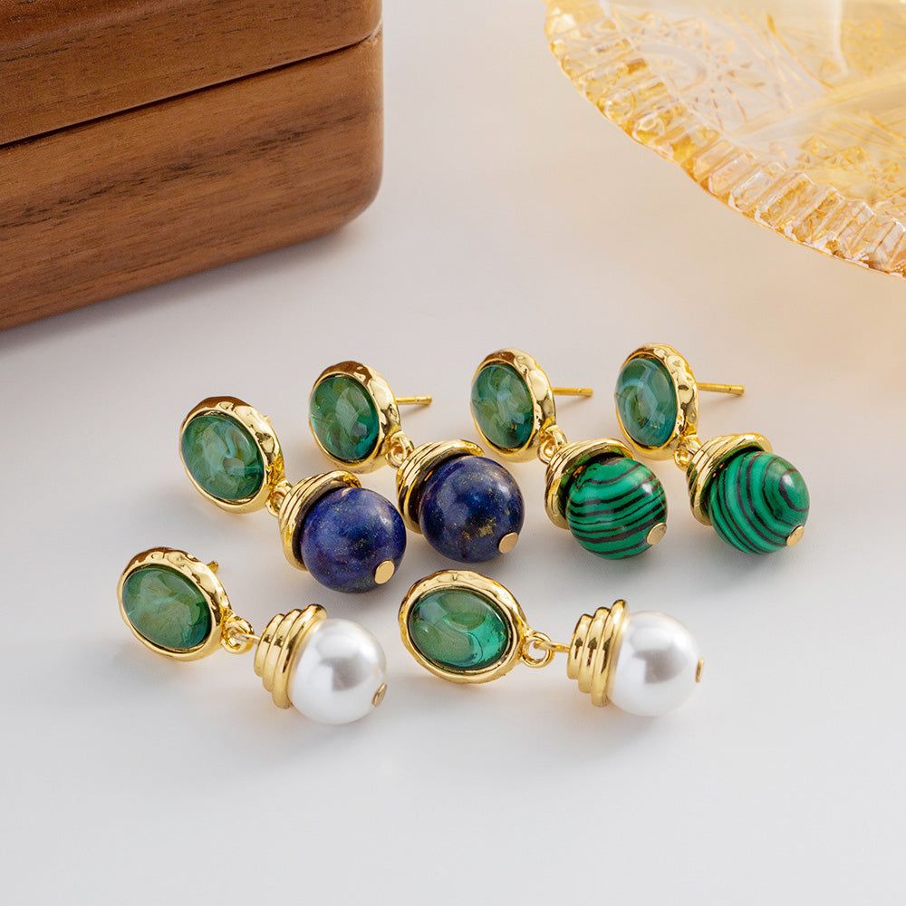 A collection of stainless steel drop earrings featuring natural gemstones like green malachite, blue lapis lazuli, and white pearls, displayed on a clean white background.