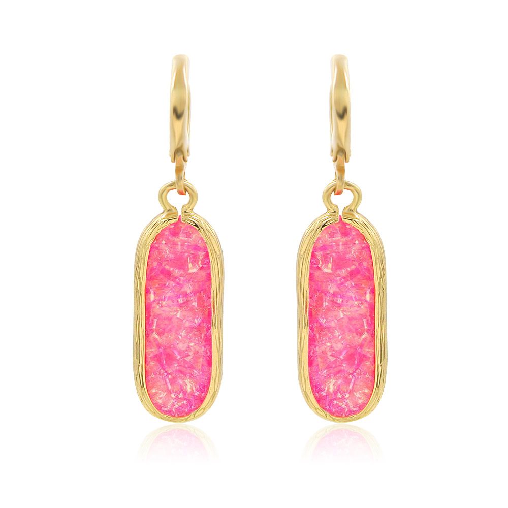Vue rapprochée des boucles d'oreilles en résine rose, mettant en valeur la pierre en résine rose faite à la main, montée sur un crochet français en laiton plaqué or.