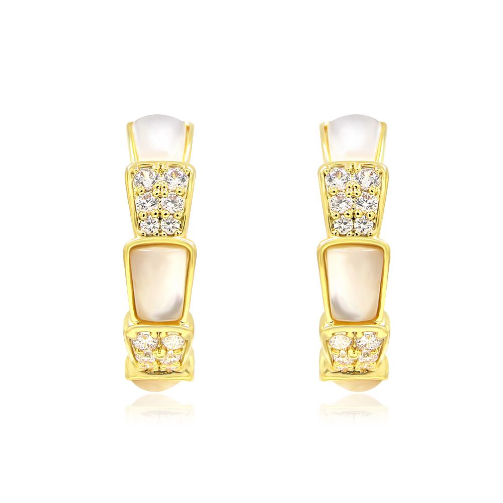 Une vue rapprochée des boucles d'oreilles en forme de serpent en coquille blanche naturelle, mettant en valeur le plaquage en or complexe, l'incrustation en nacre et les pierres en zircon cubique étincelantes.