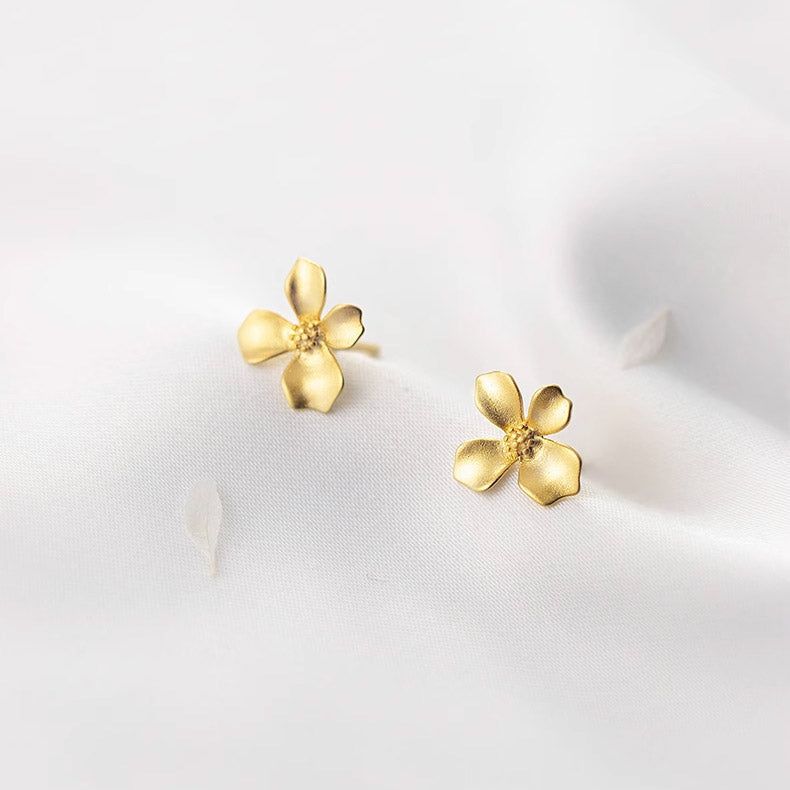 Un paio di orecchini a forma di fiore piccoli in argento sterling 925 con placcatura in oro, mostrati su uno sfondo bianco pulito.