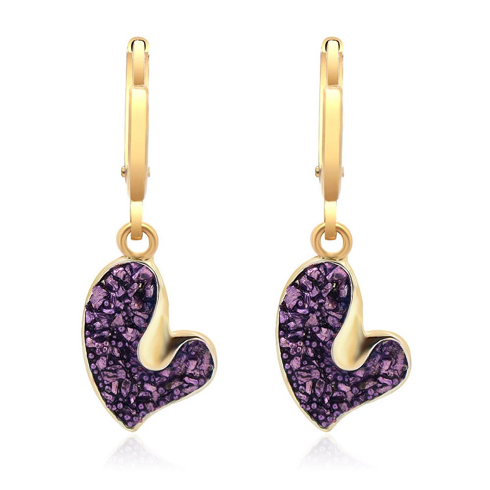 Un par de pendientes colgantes en forma de corazón con purpurina morada brillante, que presentan un colgante de corazón de acrílico morado vibrante y latón chapado en oro sobre un fondo blanco.