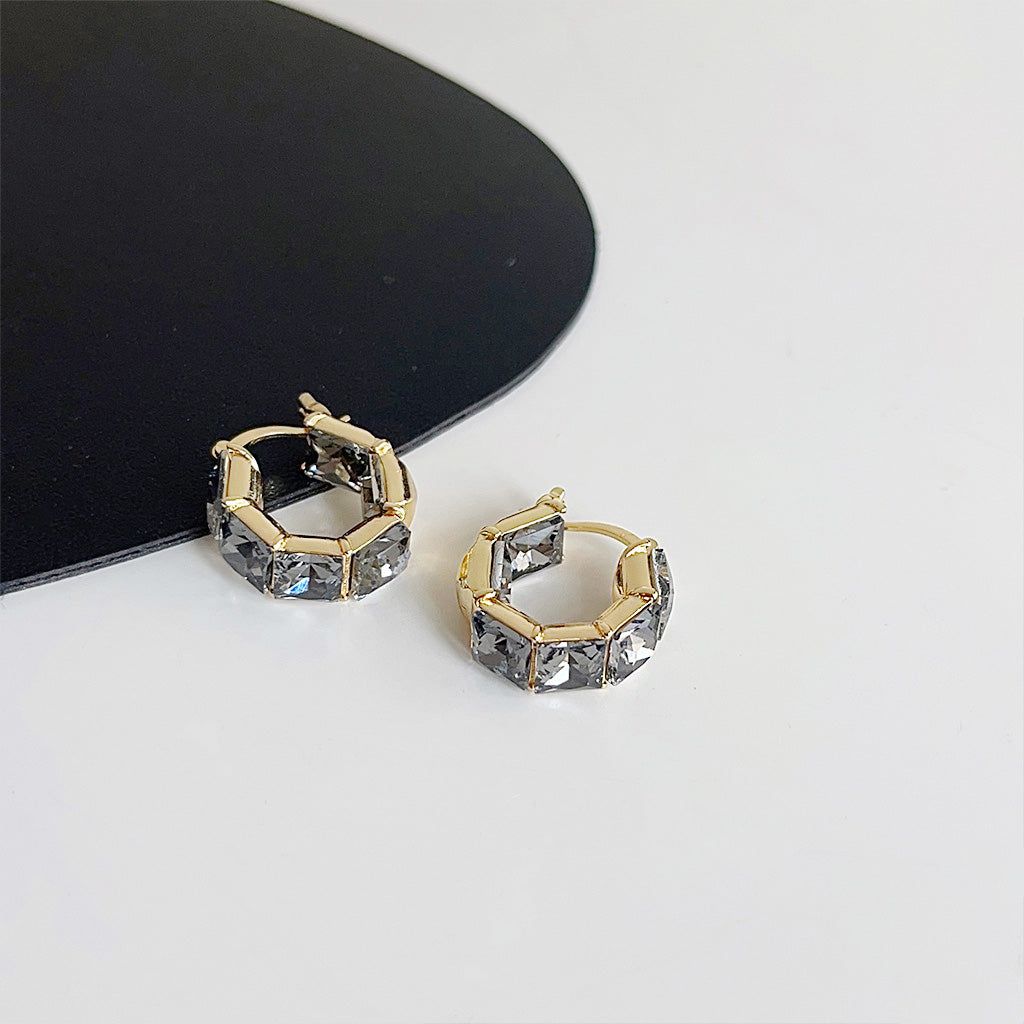 クリアで輝くガラスのラインストーンを使用した金メッキクリスタルキューブフープイヤリングのクローズアップ、エレガントなデザインを披露。