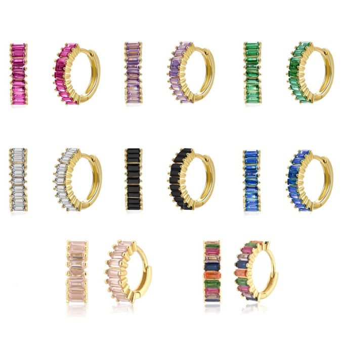 Una collezione di orecchini huggie in oro placcato con zirconie cubiche a taglio baguette che mostrano vari colori vivaci di gemme in zirconia cubica.