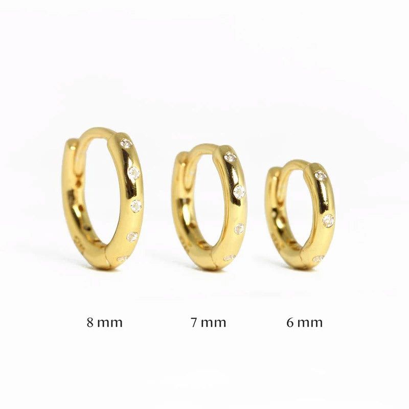 Un set di tre piccoli orecchini a cerchio in argento sterling 925 con finitura dorata, esposti nelle dimensioni 8 mm, 7 mm e 6 mm.