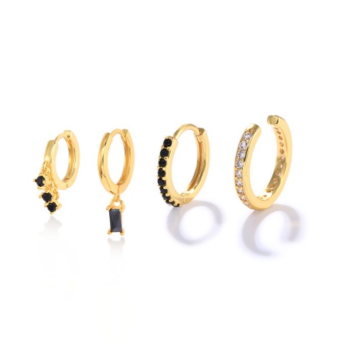 Ein Set aus vier Huggie-Ohrringen aus Sterlingsilber mit schwarzen Zirkonia und Goldbeschichtung, das verschiedene Designs mit Steinverzierungen zeigt.