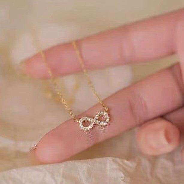 A close-up of the elegant 925 sterling silver infinity pendant necklace in a radiant gold finish, showcasing the sparkling cubic zirconia stones.