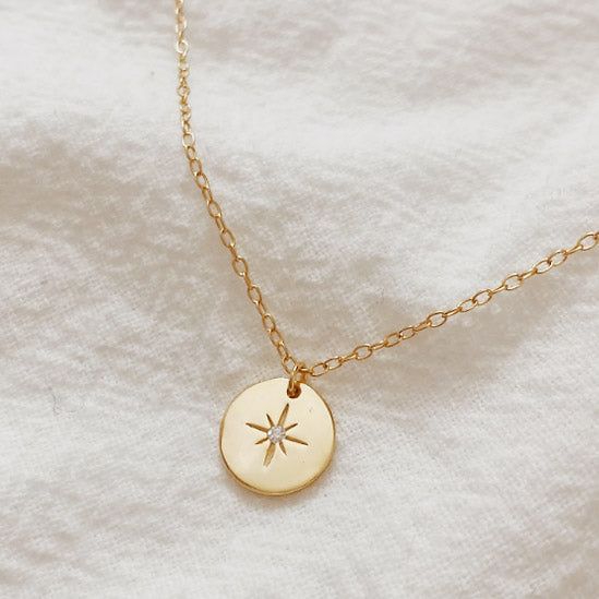 Primer plano del collar con colgante de estrella del norte de plata esterlina 925 en un acabado dorado radiante, mostrando el detallado diseño de explosión estelar.