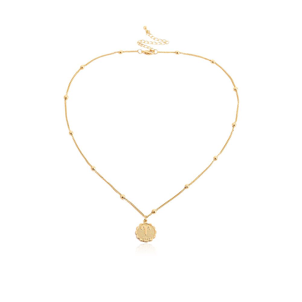 Een delicate vergulde sterrenbeeld ketting met een cirkelvormige hanger, gepresenteerd tegen een schone, lichte achtergrond.