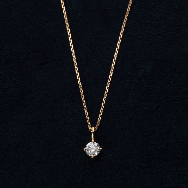 A 925 sterling silver necklace with a gold finish, featuring a sparkling solitaire stone held in a classic four-prong setting.