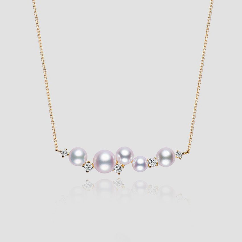 A close-up of the 925 sterling silver necklace, plated in 18K gold, featuring a delicate arrangement of lustrous shell pearl beads.