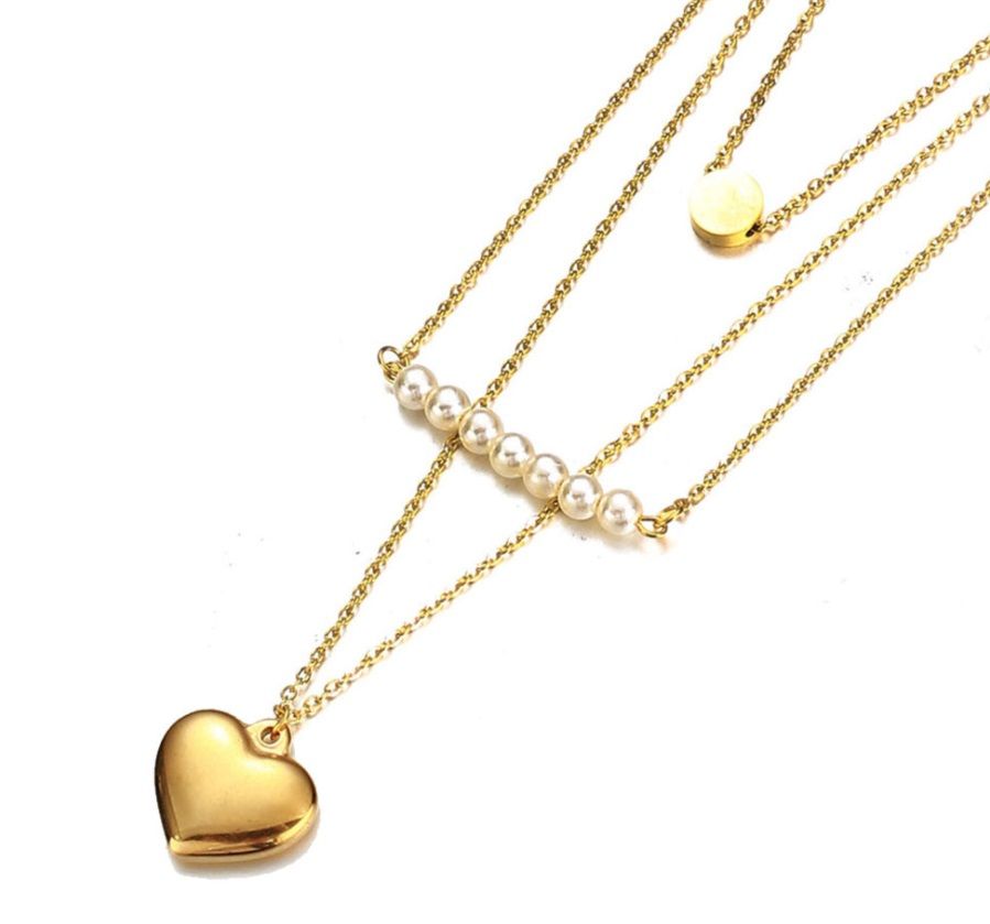 Eine stilvolle Halskette aus Edelstahl mit mehreren Lagen und goldbeschichtetem Finish, die elegante Perlen-, Herz- und Scheibenanhänger enthält.
