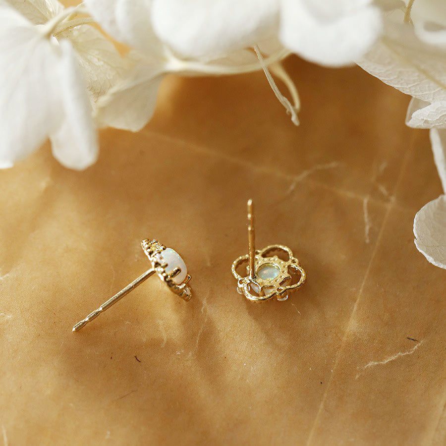 Een paar minimalistische 925 sterling zilveren stud oorbellen met een bloemmotief, met een centrale witte opaal edelsteen omringd door sprankelende zirkon accenten.