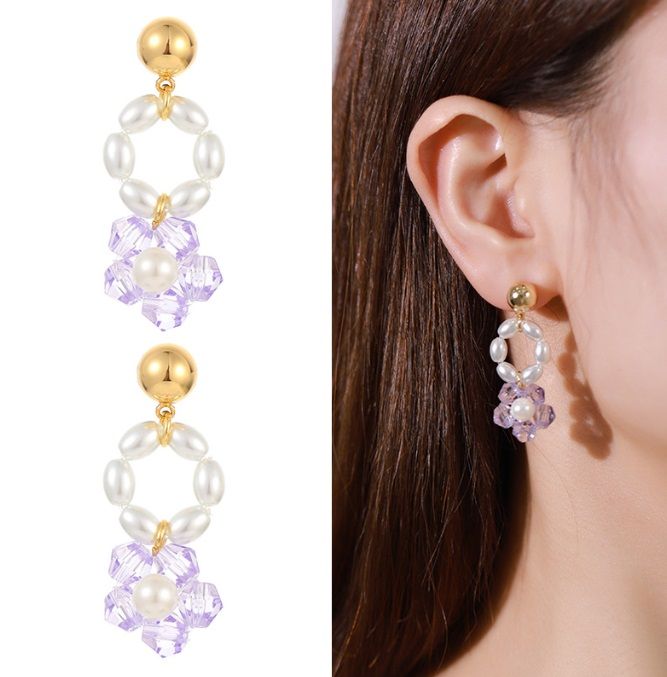 Un par de pendientes colgantes de cristal floral con cuentas y baño de oro, que exhiben racimos de cristales morados y una sola perla blanca en la parte superior.
