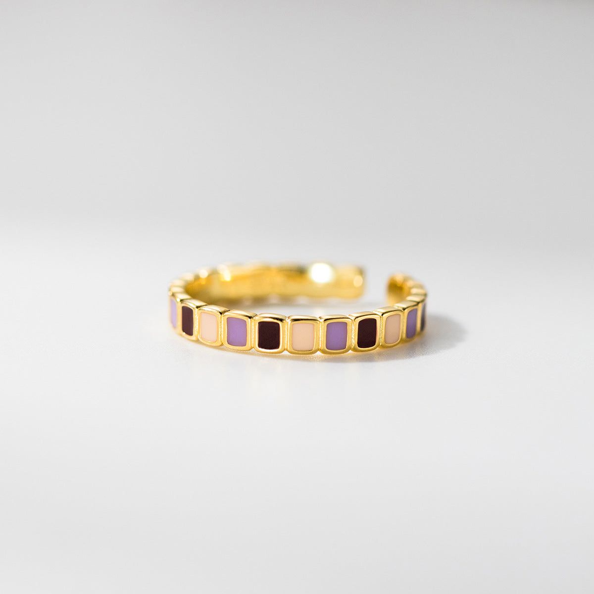 Nahaufnahme eines verstellbaren Rings aus 925er Sterlingsilber im Großhandel mit vergoldeter Oberfläche und lebhaften Farbblock-Emaille-Einlagen in Lila, Creme und Burgunder.