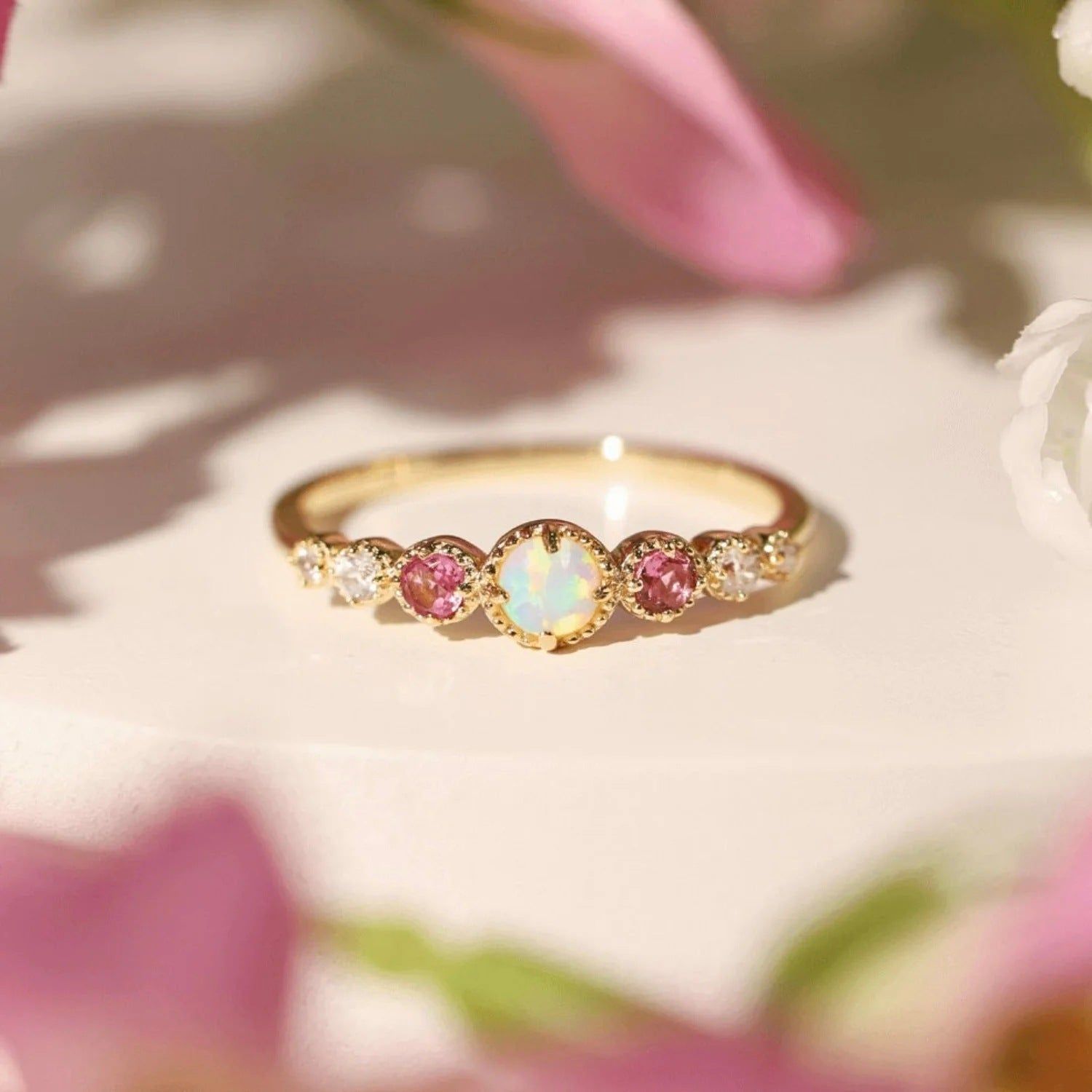 Ein atemberaubender vergoldeter Ring aus 925er Sterlingsilber mit einem strahlenden weißen Opal in der Mitte, umgeben von zarten rosa und weißen Zirkonsteinen.