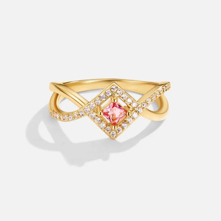 Un primer plano del anillo de plata esterlina 925 con baño de oro de 18K, que presenta un zircon rosa cuadrado en el centro rodeado de zircones brillantes como diamantes.