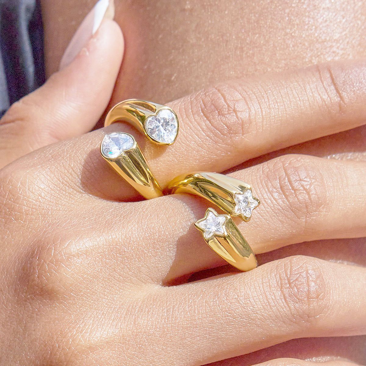 A set of five adjustable gold star rings with sparkling zircon stones, crafted from non-tarnish stainless steel, displayed on a neutral background.