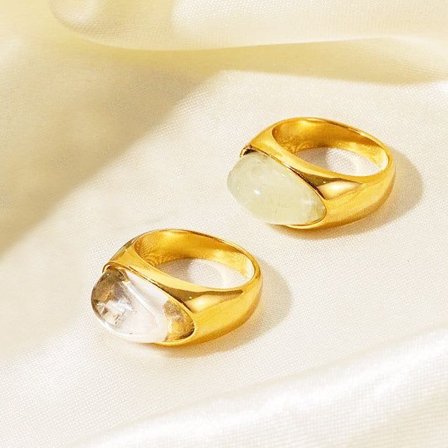Een close-up van twee roestvrijstalen ringen uit de 5-delige set, met grote, elegante witte opaal natuurlijke stenen.