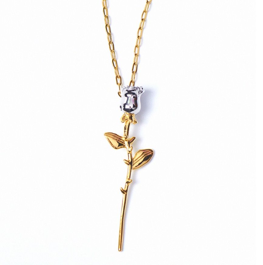 Close-up of the Dainty Two Tone Rose Necklace, showcasing the gold rose stem pendant with a sparkling crystal bead on a delicate chain.