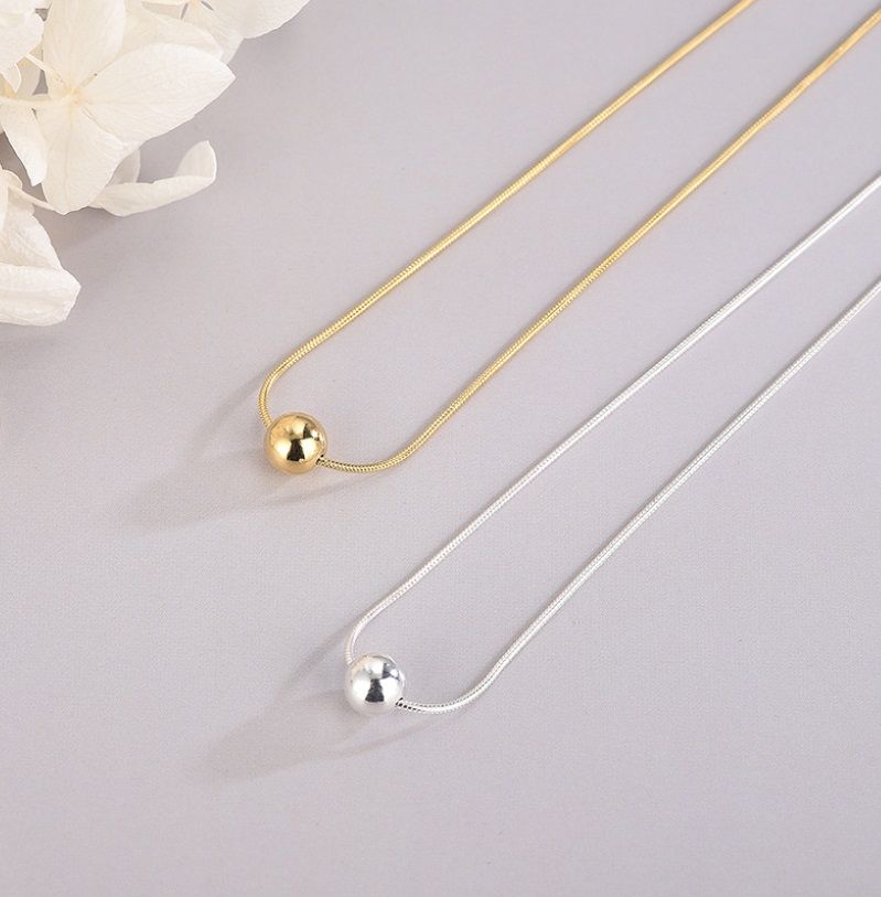 A pair of 925 Sterling Silver Floating Ball Necklaces, one in gold and one in silver, showcasing the elegant spherical pendant design.