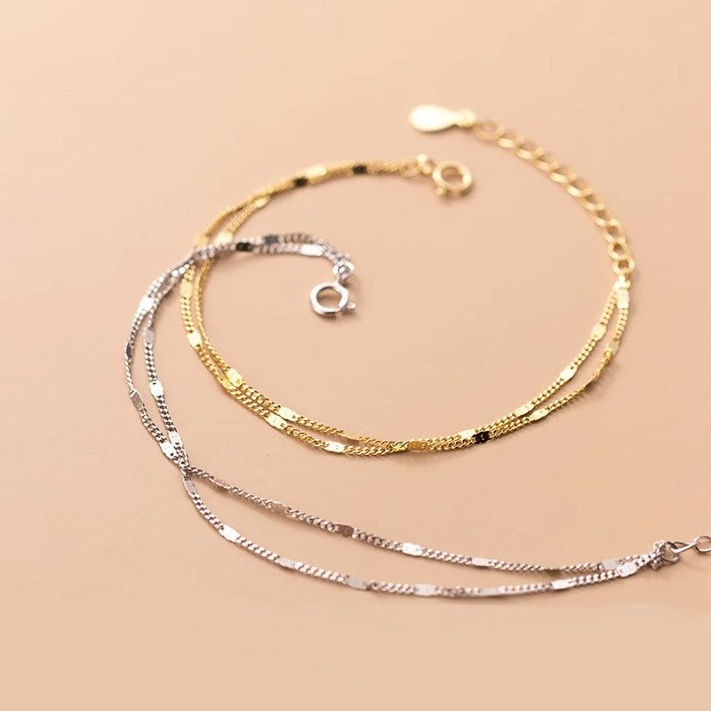 Un ensemble de bracelets en chaîne à deux couches en argent sterling 925, présentant les options de couleur or et argent sur un fond neutre.