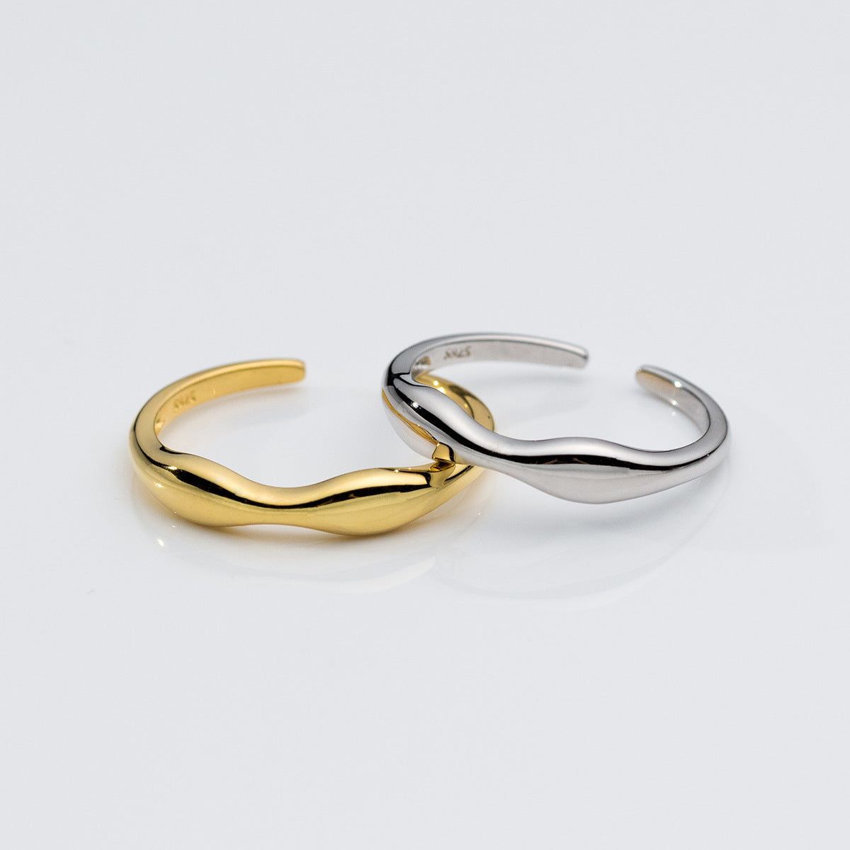 A set of 925 sterling silver slim wavy Mobius strip stackable open rings, shown in both gold and silver finishes.