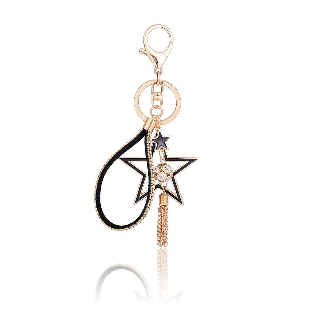 Um close do Chaveiro Estrela Dourada de Cristal Bling, mostrando o detalhado pingente em forma de estrela com cristais pretos e dourados, uma alça de couro PU preto e um delicado tassel de corrente dourada.