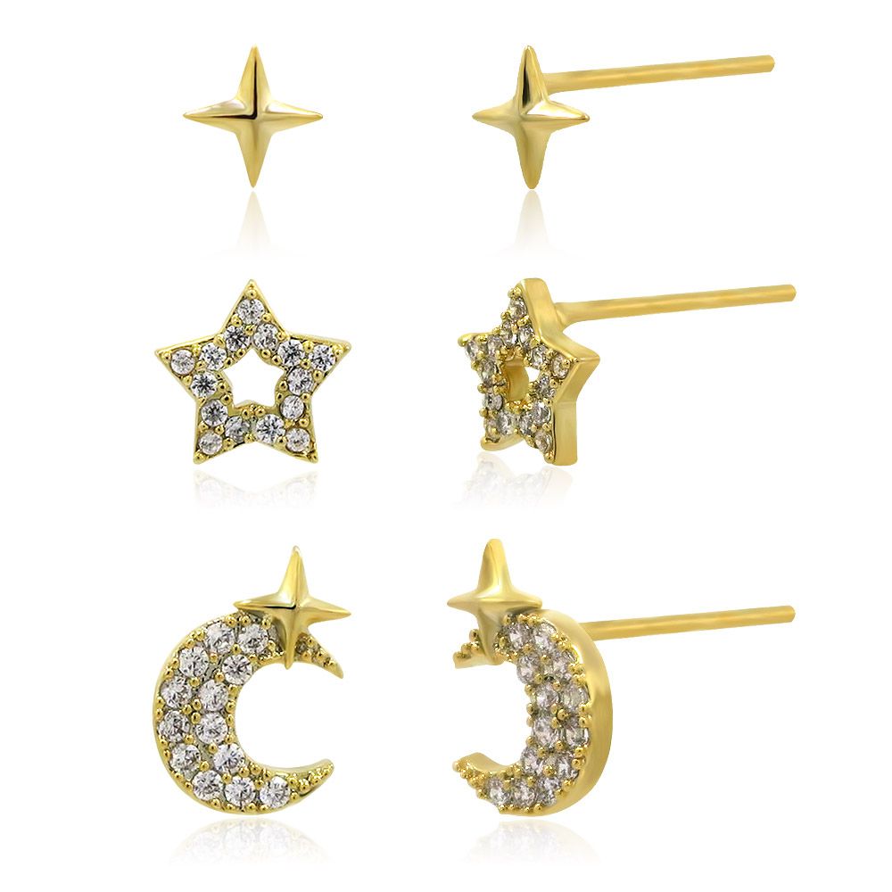Un set regalo completo di orecchini a forma di stella e luna che mostra tre paia di orecchini a bottone placcati in oro: una stella lucida, una stella con zirconia cubica e una luna crescente con una stella.