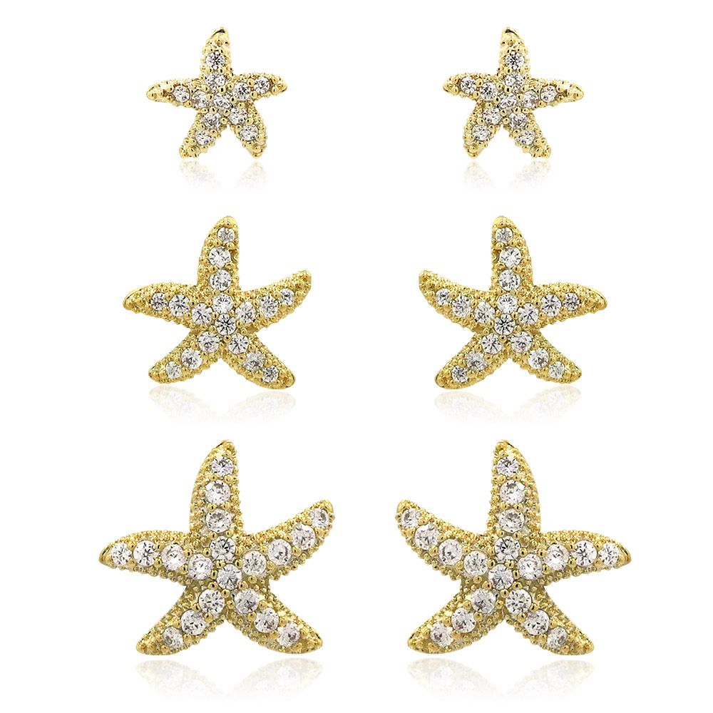 Une photo promotionnelle du pack multi de trois paires d'étoiles de mer dorées, mettant en valeur les boucles d'oreilles dorées avec des pierres en zircon cubique étincelantes.