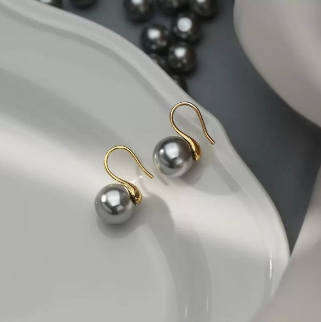 Un paio di orecchini a gancio in argento sterling 925 con perla grigia e ganci dorati eleganti, mostrati su uno sfondo bianco.