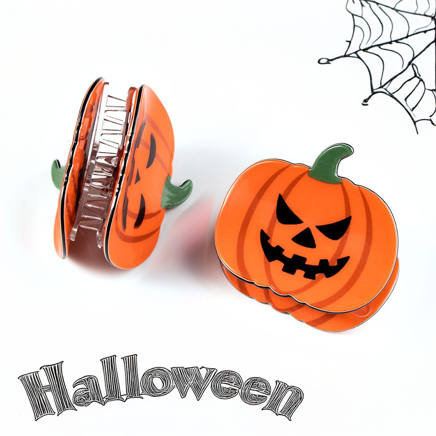 A set of three pumpkin-shaped Halloween hair claw clips with smiling jack-o'-lantern faces against a white background.