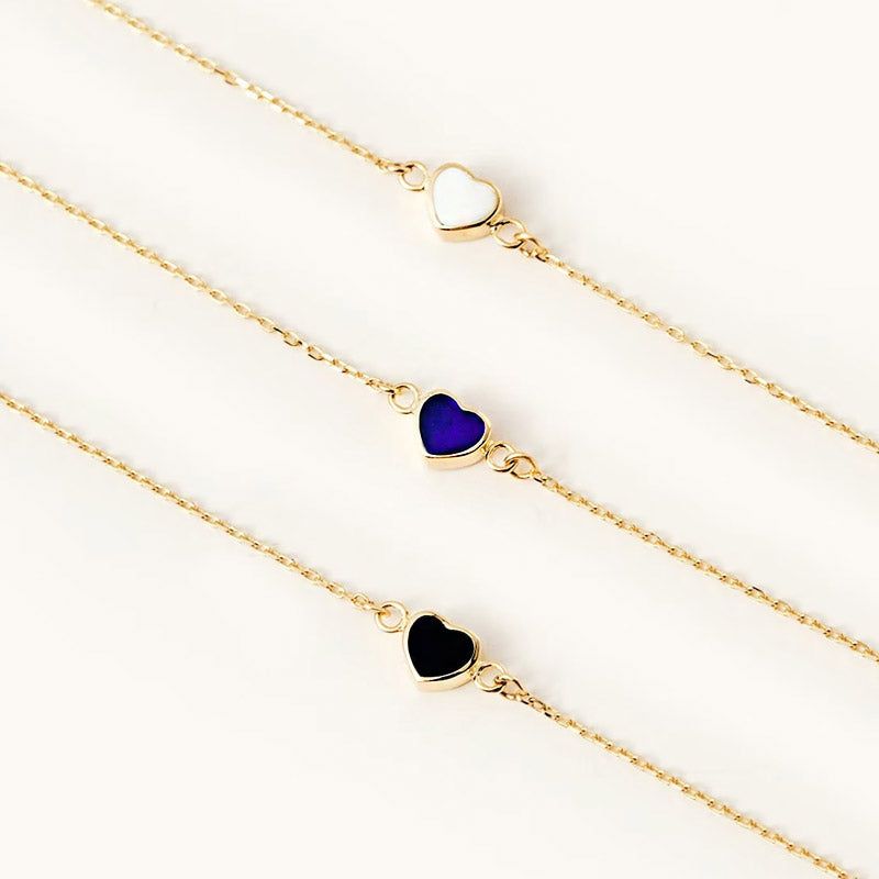 A set of three 925 sterling silver enamel heart charm bracelets in white, black, and blue, displayed together to showcase the color options.