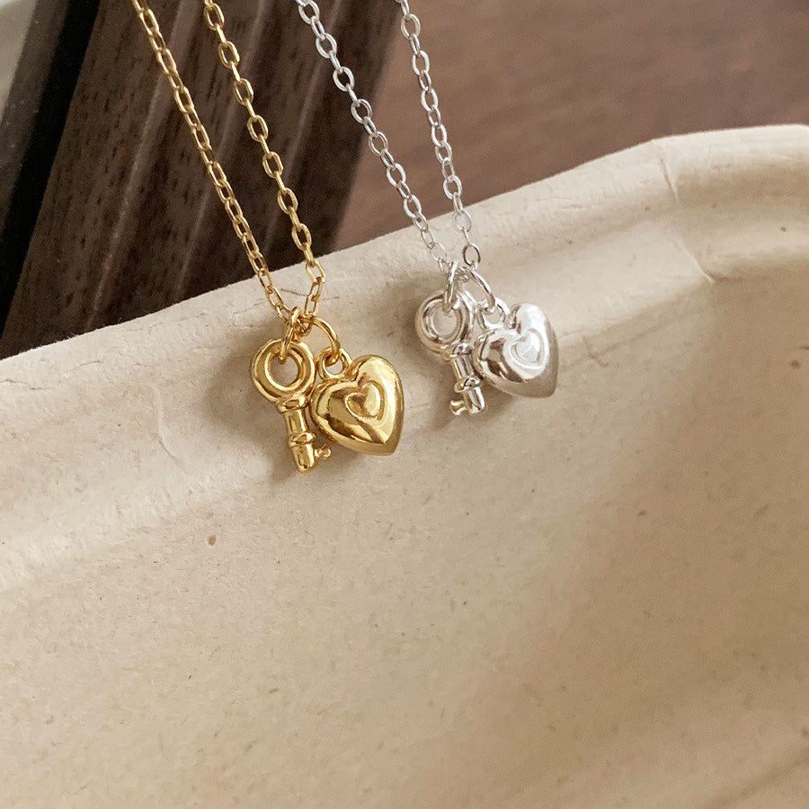 Un ensemble de vente en gros de colliers en pendentif mini cœur clé en argent sterling 925, affichant à la fois les options élégantes en or et classiques en argent côte à côte.