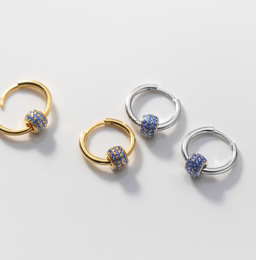 Eleganti orecchini a cerchio in argento sterling 925 con cluster di zirconia cubica blu e trasparente, mostrati sia in placcatura oro che rodio.