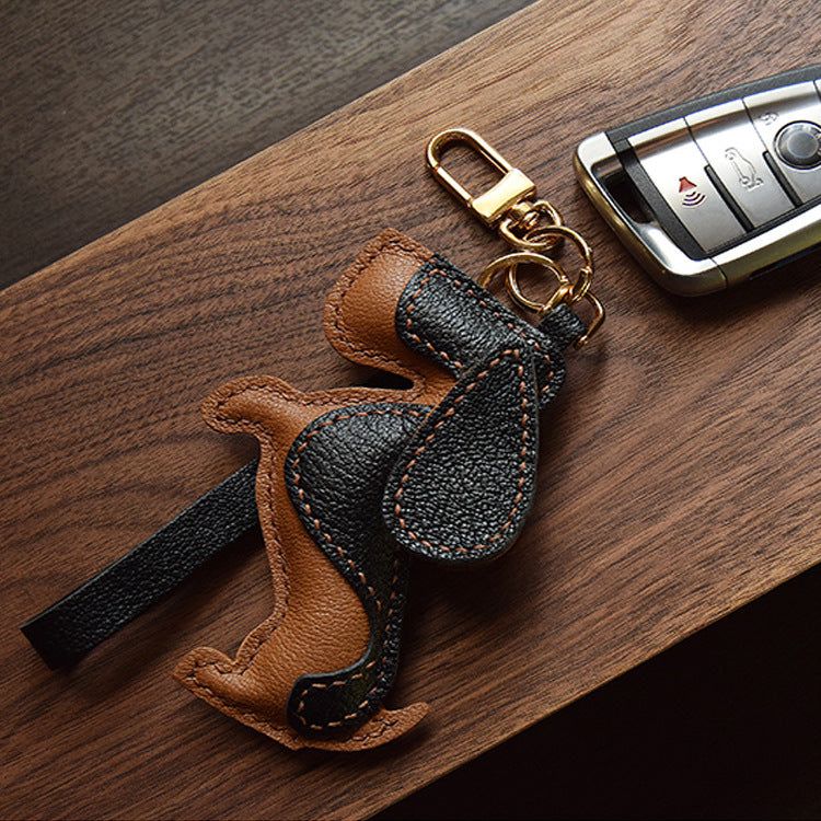 Un porte-clés en cuir véritable de Basset Hound de qualité supérieure montré à côté d'un porte-clés de voiture, mettant en avant son utilisation comme accessoire de voiture élégant.